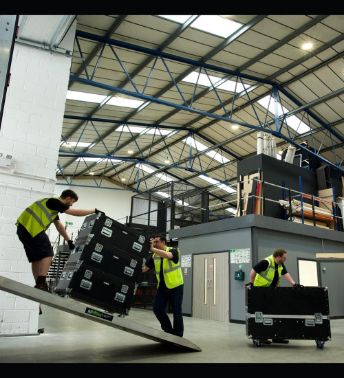 an events crew loading boxes on wheels in a warehouse.
