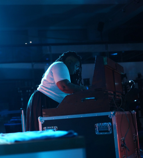 person operating technical event gear in a darkly lit venue.